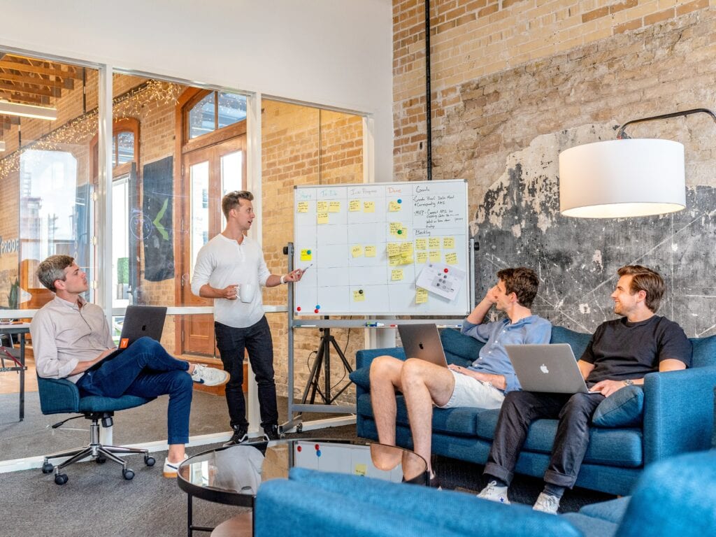 investor meeting around a white board in an office