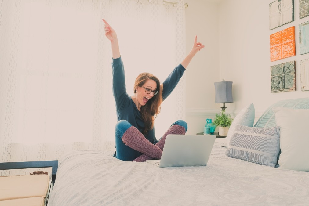 woman in bed realizing she made money while she slept at Bear Financial Solutions